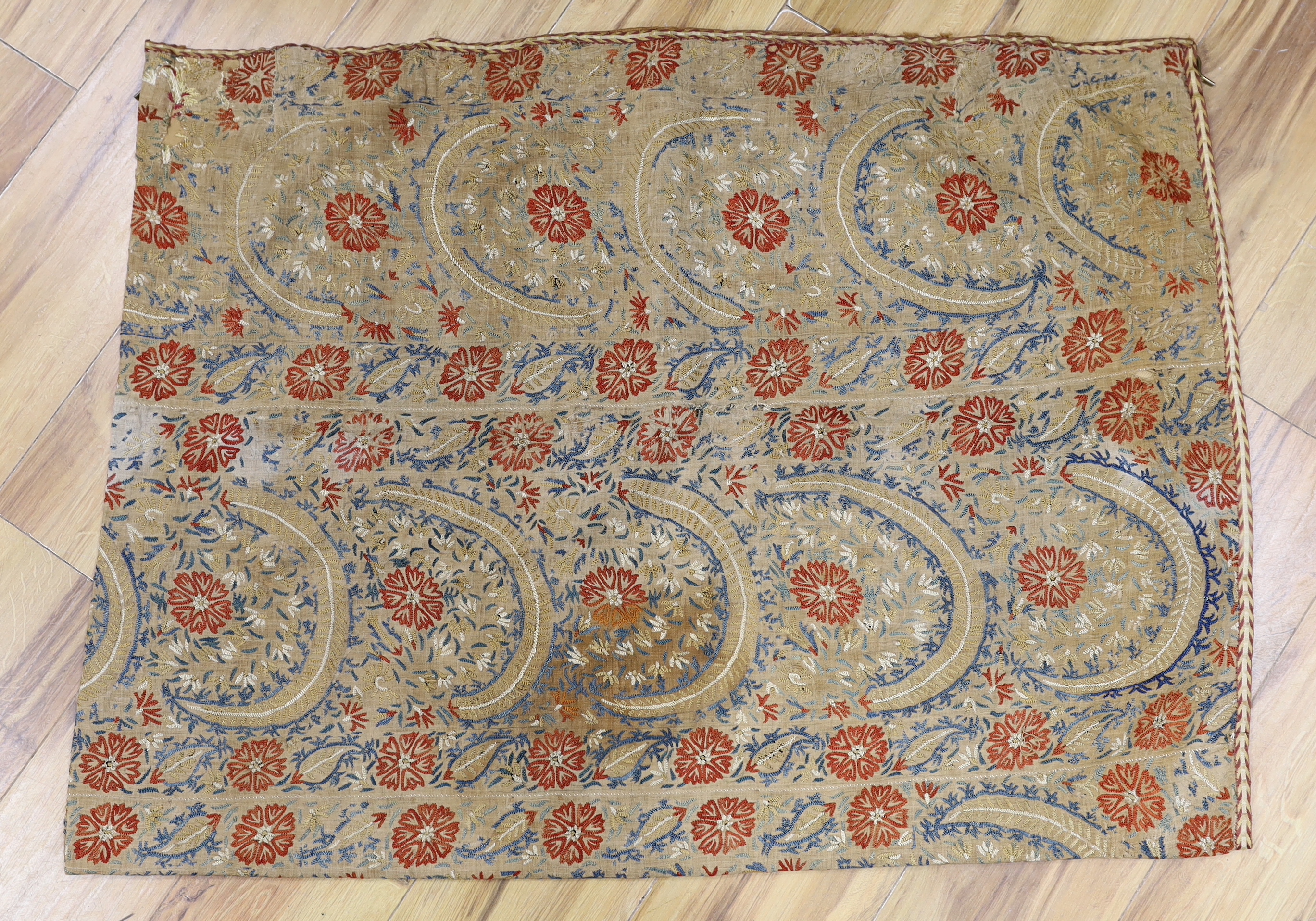 An Indian embroidered panel, a small linen embroidered panel possibly Turkish, a maroon silk length of fabric, heavily embroidered with all over flower motifs, possibly cut from a sari, together with a handwoven linen em